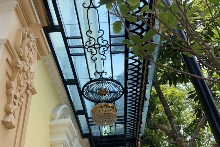 Mái hiên đẹp kính cường lực kết hợp với bộ đèn chùm phong cách cổ điển
