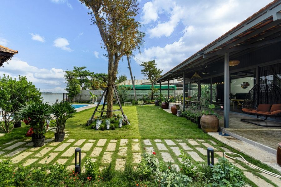 Sân vườn biệt thự xanh mát với lối đi được lát gạch cẩn thận